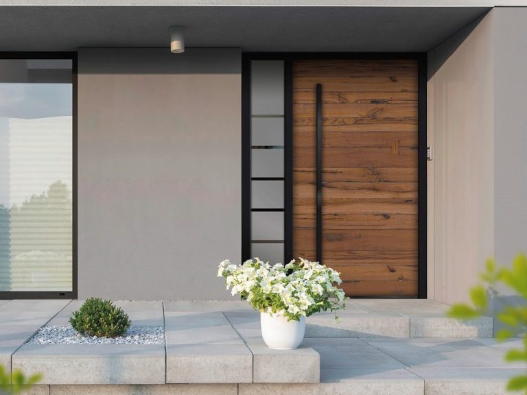 Moderne Hauseingang mit Holzoptik und weißen Blumen in einem Topf.