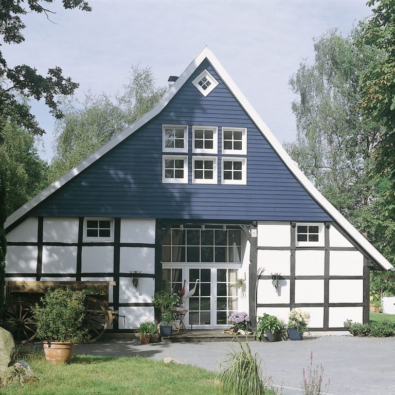 Traditionelles Fachwerkhaus mit blauem Obergeschoss und weißer Fassade.