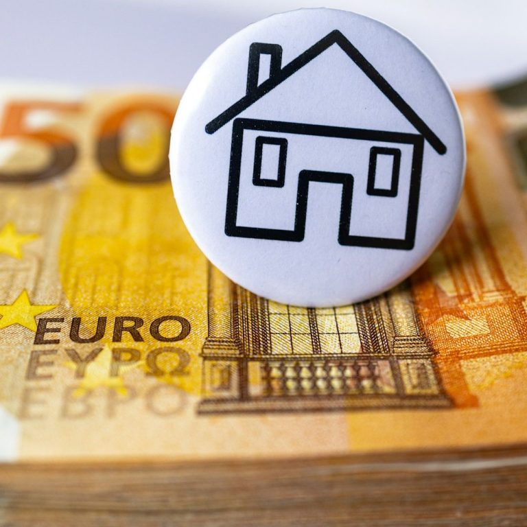Haus-Symbol auf einem Stapel von Euro-Banknoten.