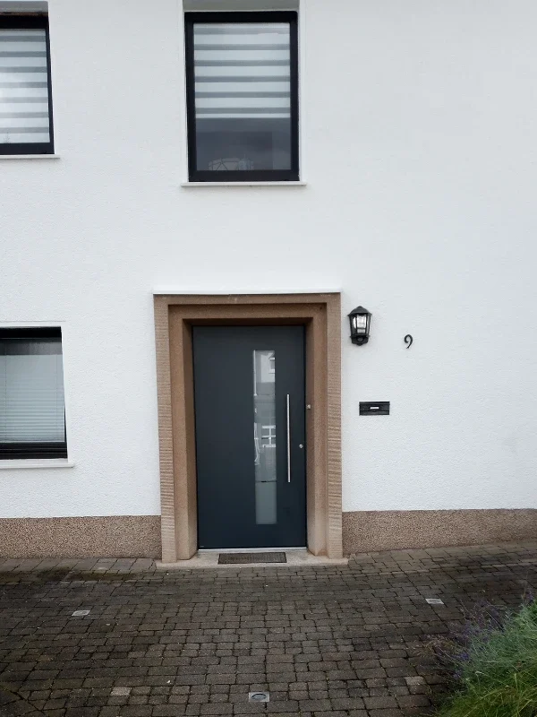 Haustür und Fenster mit weißer Fassade