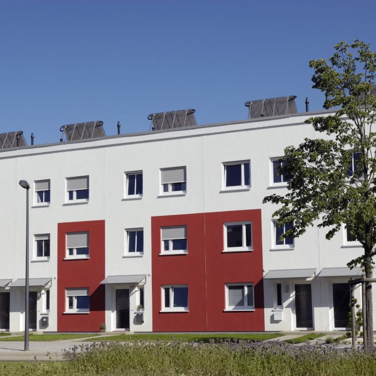Moderne Wohnanlage mit roten Akzenten und mehreren Fenstern.