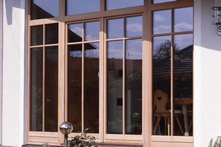 Holzfenster mit mehreren Sprossen und Blick auf einen Innenraum.